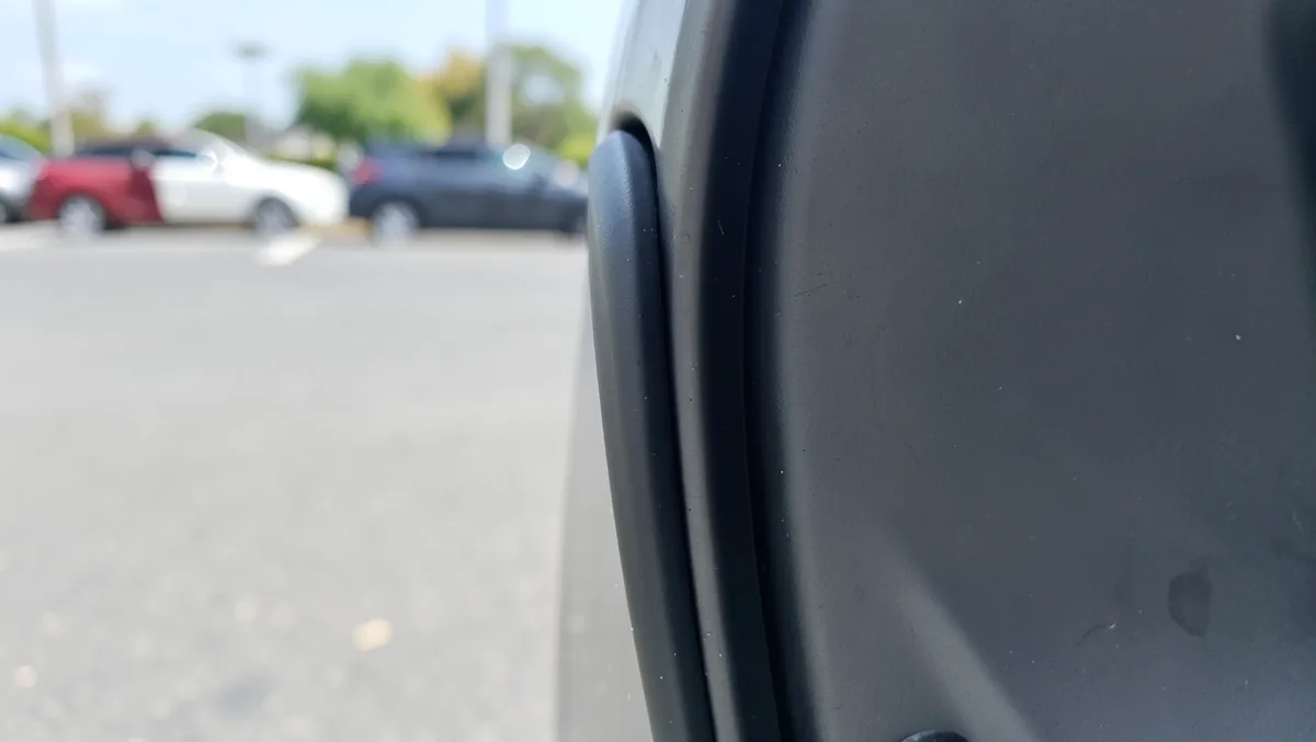 Black rubber weatherstrip seal pressed into the metal door channel of a car