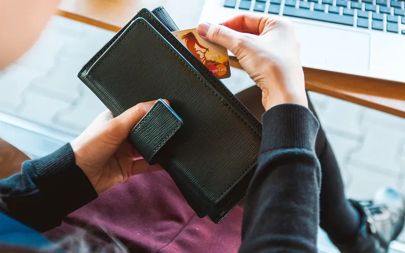 Hand pulling a credit card out of a wallet