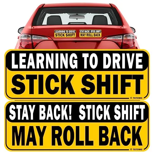 TOTOMO Learning to Drive Stick Shift reflective bumper magnet shown on the rear window of a red car