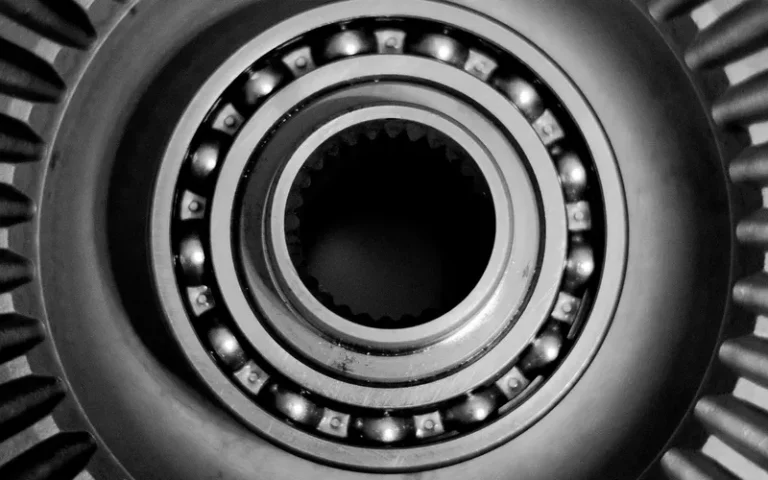 Close-up of a ball bearing with steel balls in a cage between inner and outer rings