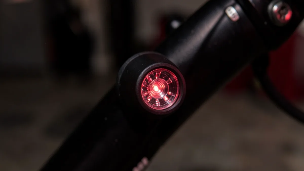 Small wireless LED puck light with magnetic base clipped to a motorcycle fork tube