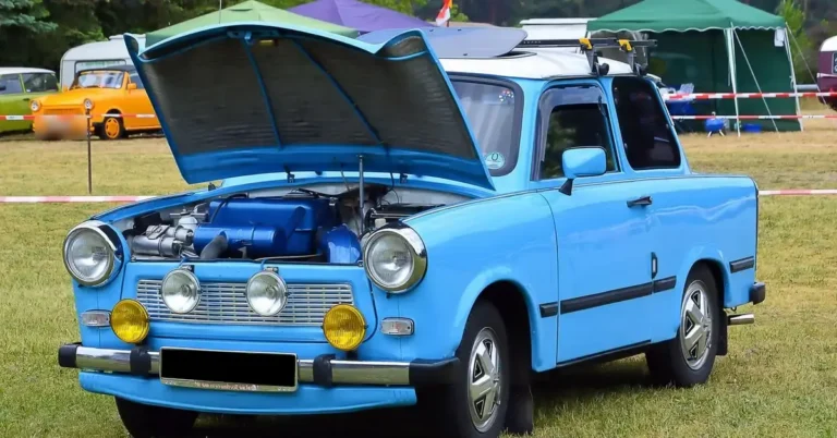 Blue classic car with its hood raised at an outdoor car show