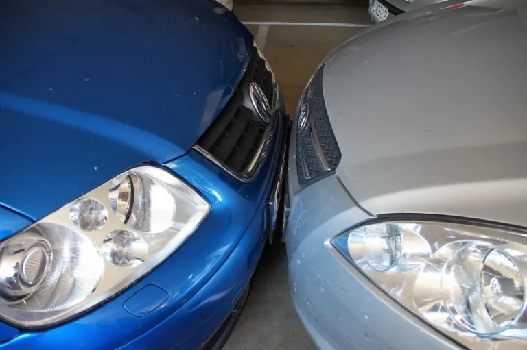 Two cars parked very close together in a parking garage