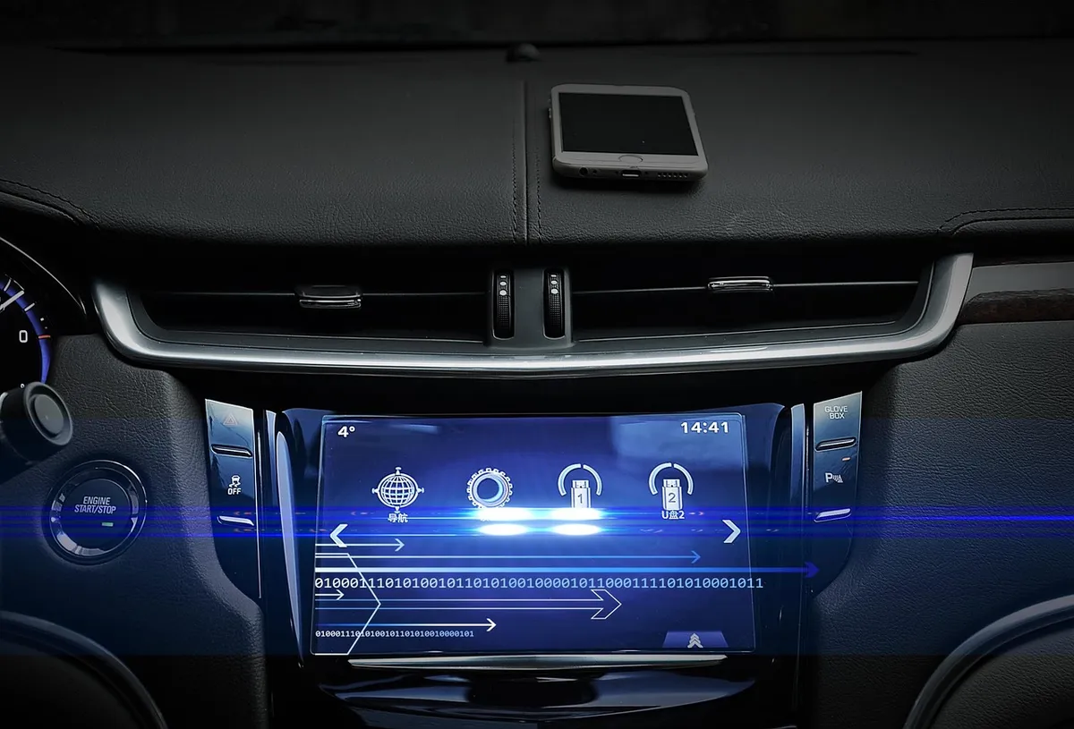 Car dashboard touchscreen with a phone resting on the dash