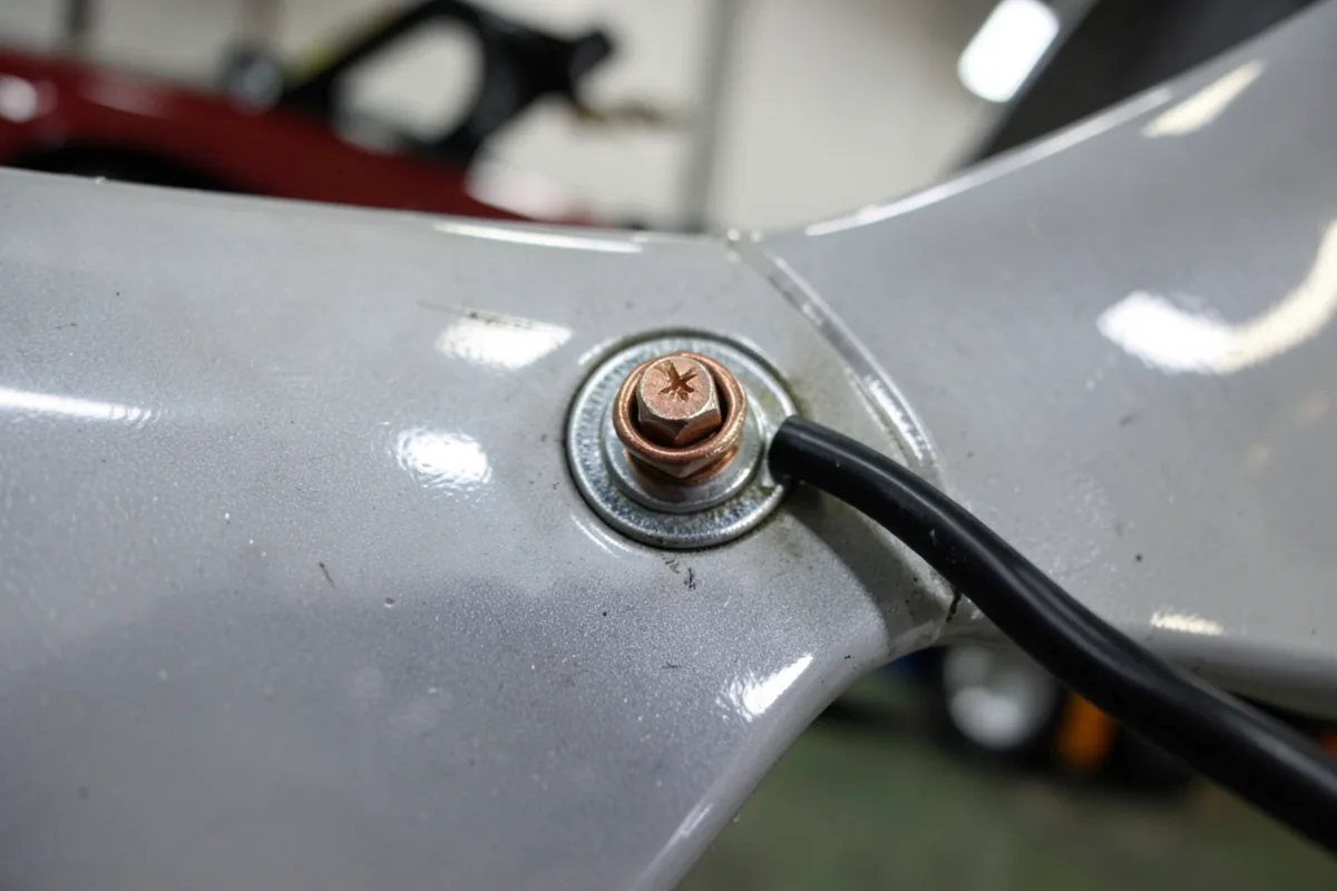 Bare metal chassis bolt with a ring terminal ground wire connection