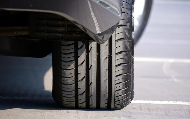 Close-up of a car tire tread resting on pavement