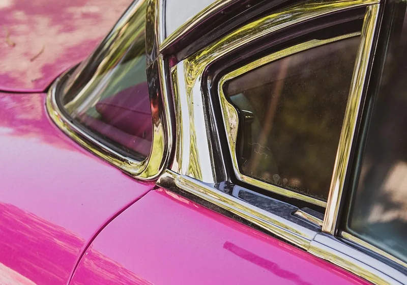 Chrome trim strips around a car side window and door seam
