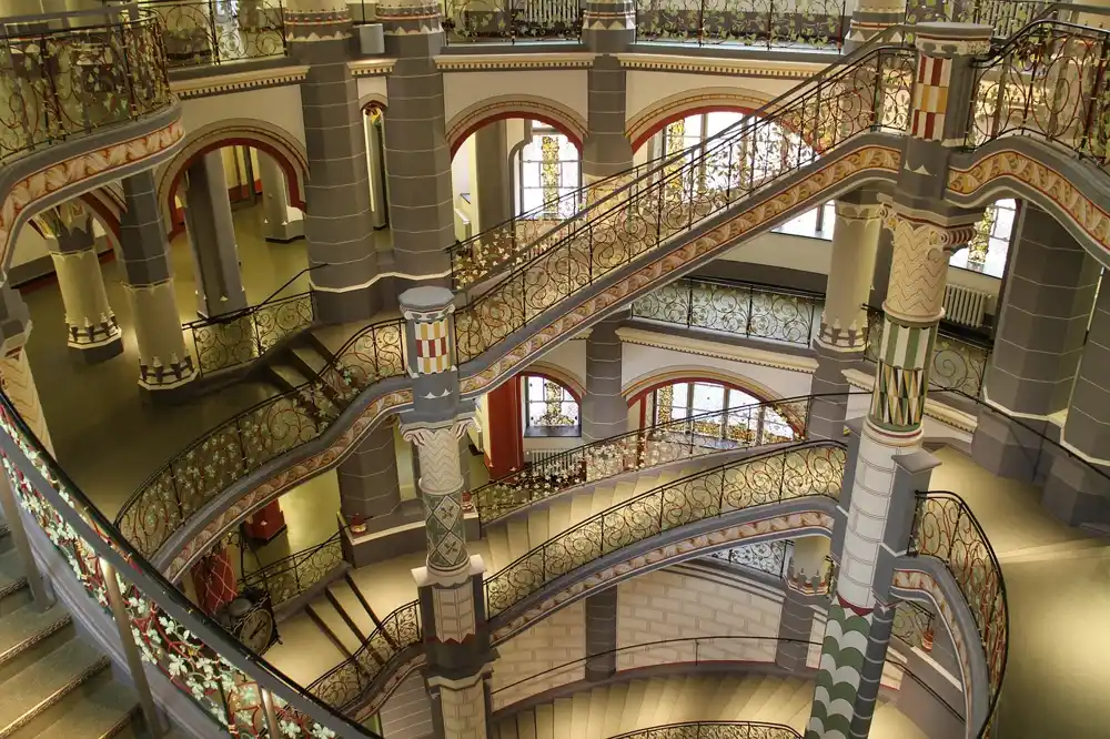 Interior of a courthouse building with curved staircases, decorated railings and columns