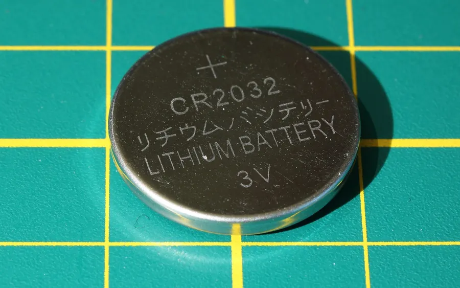 CR2032 3V lithium coin cell battery close-up with plus marking and type printed on top