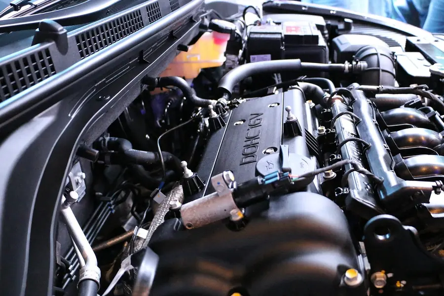 Engine bay with the engine cover, hoses and a translucent coolant reservoir at the top left