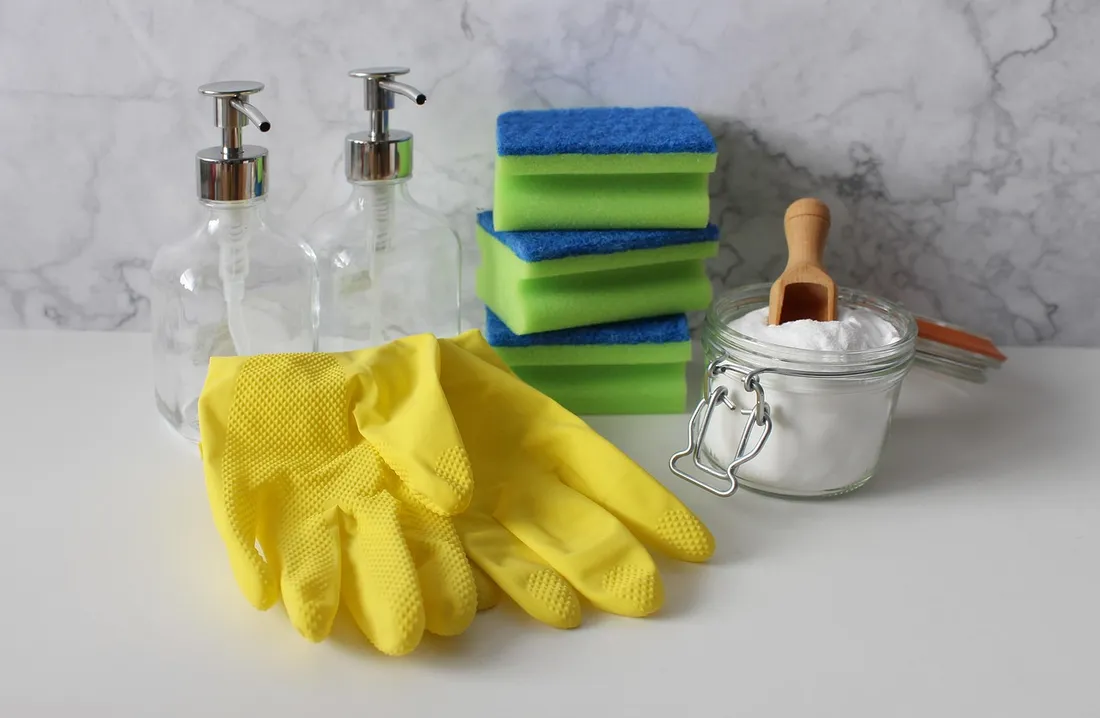 Rubber gloves, sponges and cleaning supplies laid out on a table
