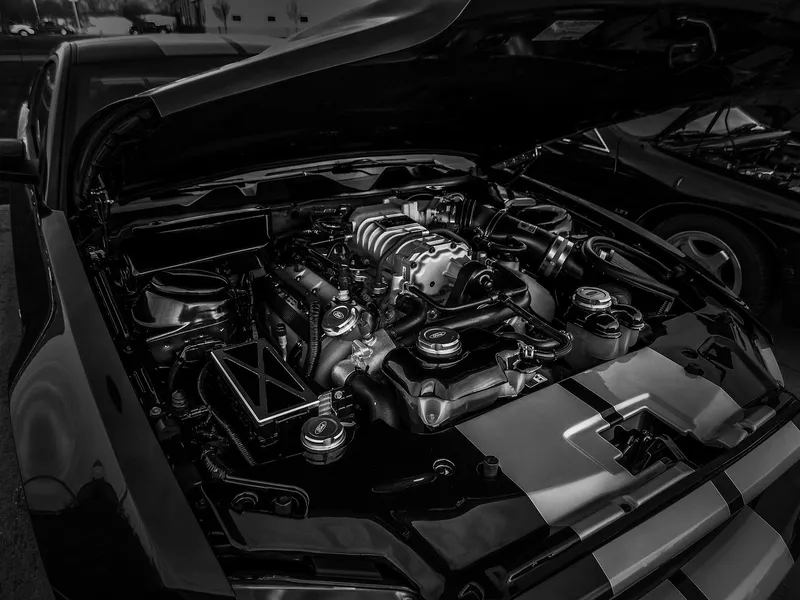 Black and white view of an engine bay with the hood open