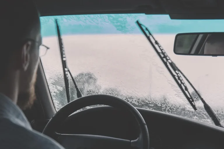 View from the driver seat of a fogged windshield with wipers visible