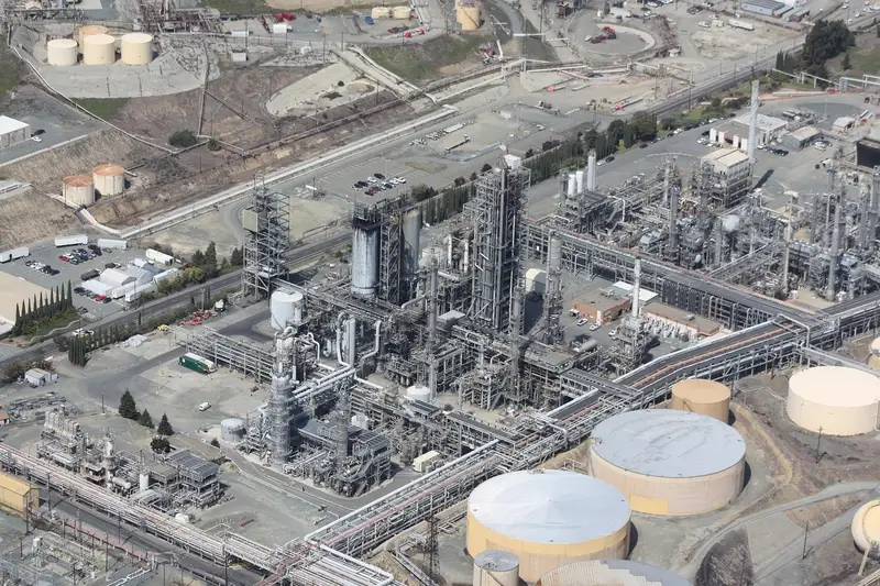 Aerial view of an oil refinery with storage tanks and processing towers