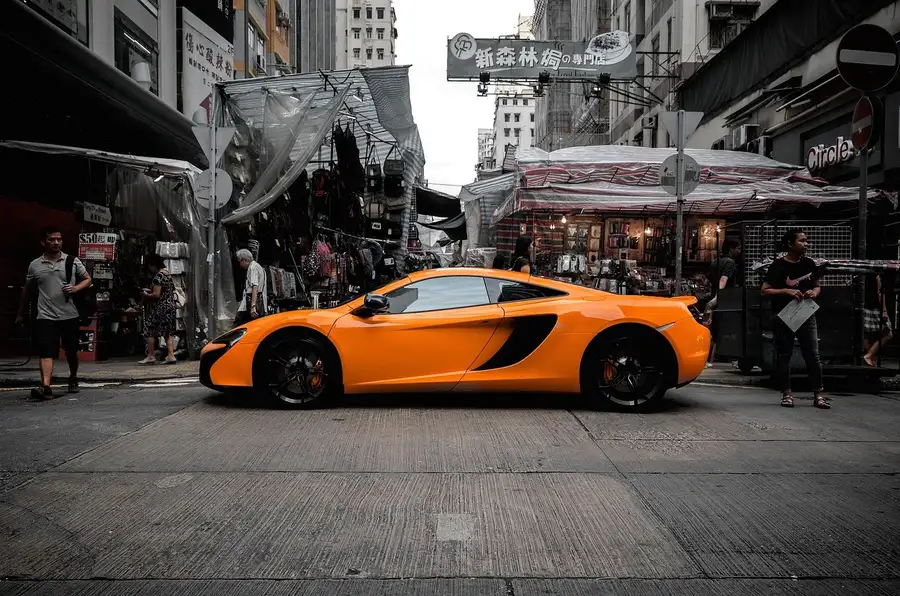 Orange supercar parked on a busy city street, like the streets worth patrolling for rare cars in GTA 5