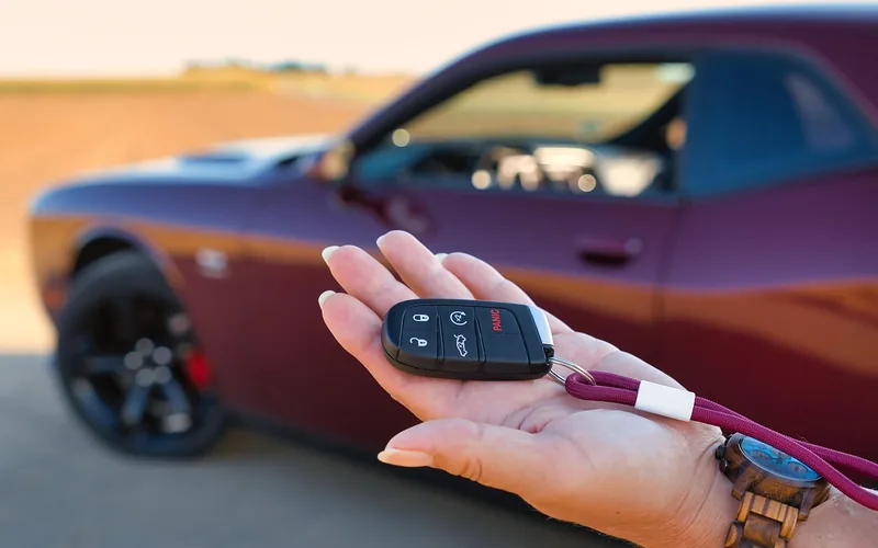 Hand holding a car key near the ignition, part of the resync process