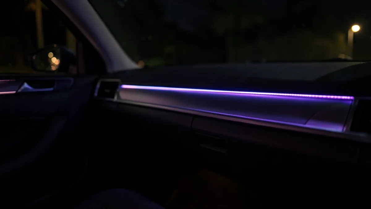 Purple LED ambient light strip glowing along a car dashboard trim at night