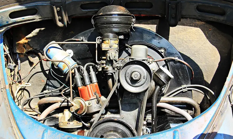 Older car engine bay with a belt-driven pulley and wiring visible