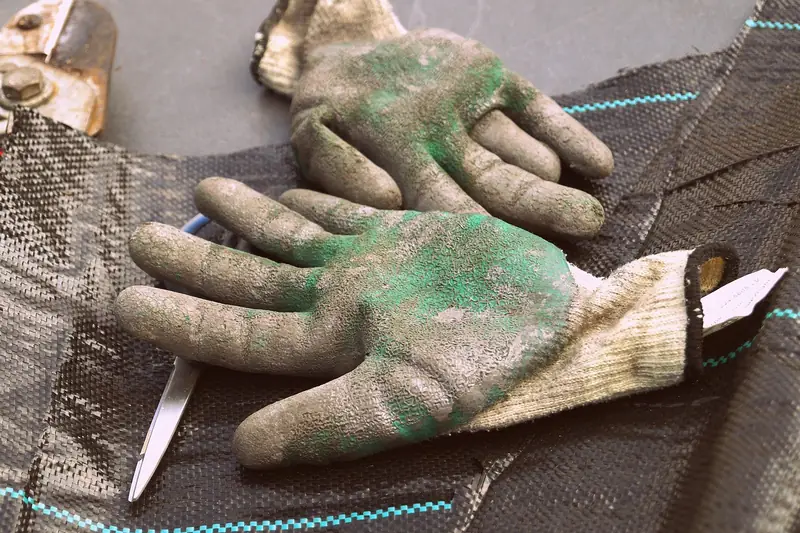 Pair of worn work gloves lying on a surface