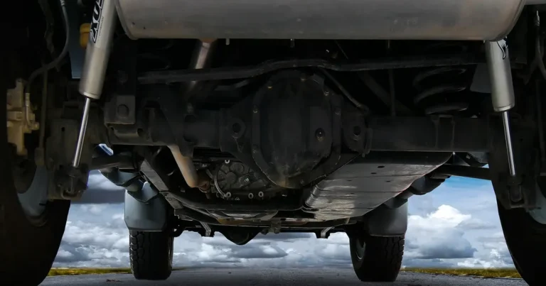Vehicle underbody with exhaust, axle and frame rails where a tracker could be attached