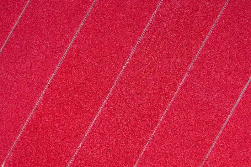 Close-up of the abrasive surface of red sandpaper