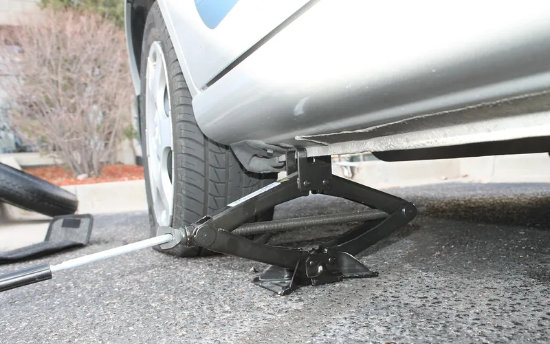 Mechanic checking a flat car tire for damage before repair