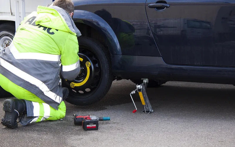Roadside assistance technician responding to a flat tire breakdown
