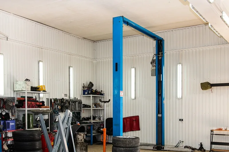 Service garage with a two-post vehicle lift and an engine hoist