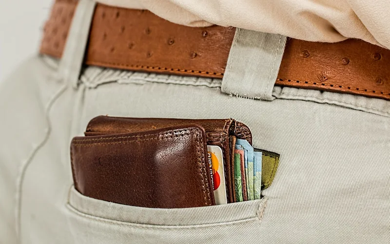 Brown leather wallet with cards and cash in a back pocket
