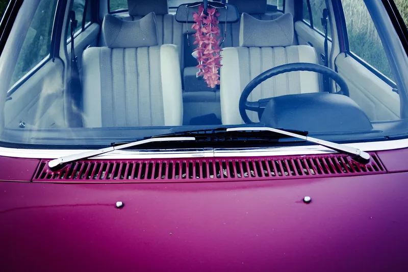 Front windshield of a parked car with the seats and steering wheel visible inside
