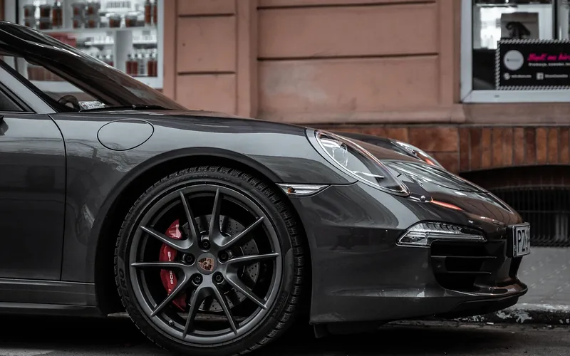 Black car's front bumper and lower fascia parked on a city street Black car's front bumper and lower fascia parked on a city street