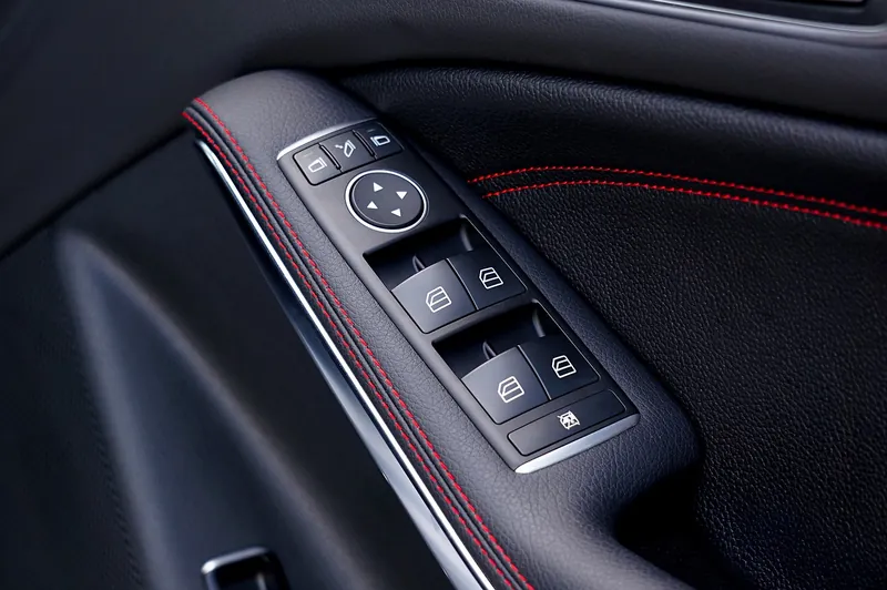 A driver's door panel with its switch cluster of window and mirror controls