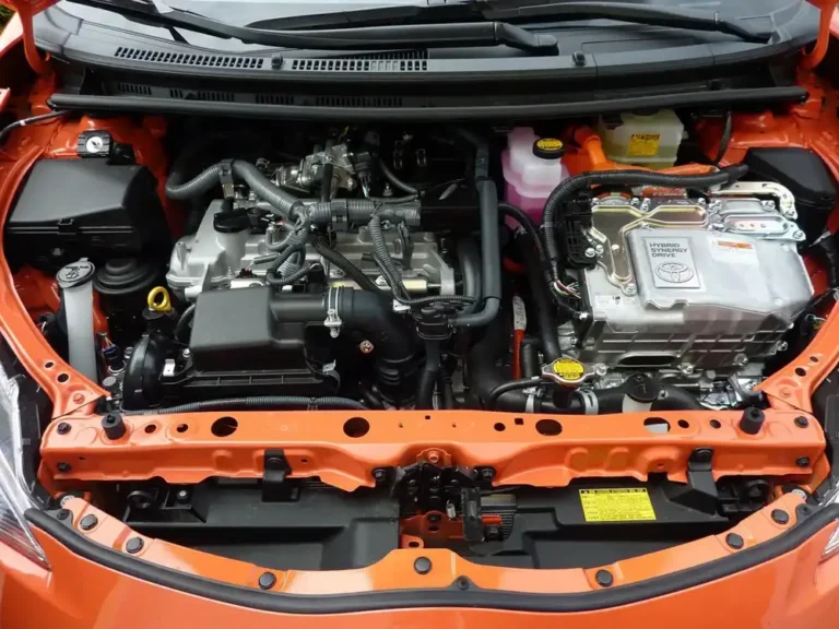 Open hood of a modern car showing the engine bay where the A/C lines and service ports sit
