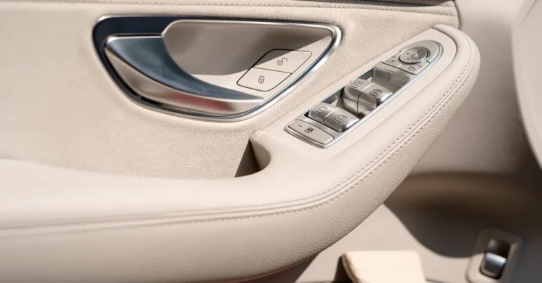 Close-up of a car interior door handle with lock buttons and window switches