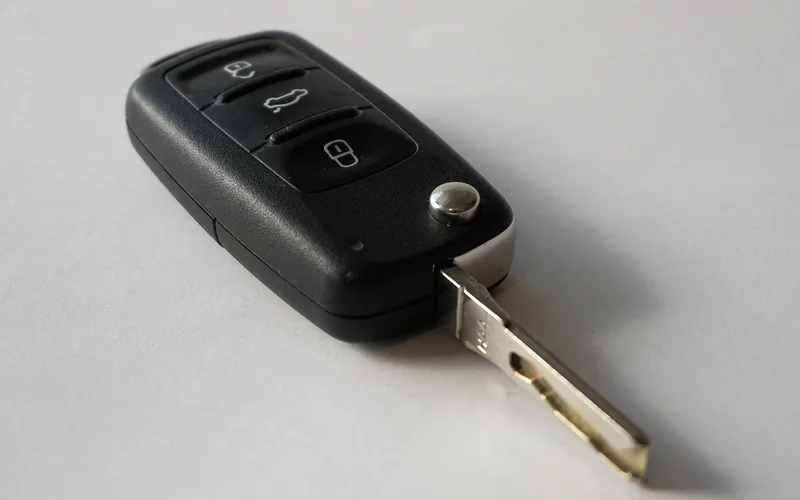 Car key inserted into the ignition lock cylinder next to the steering wheel