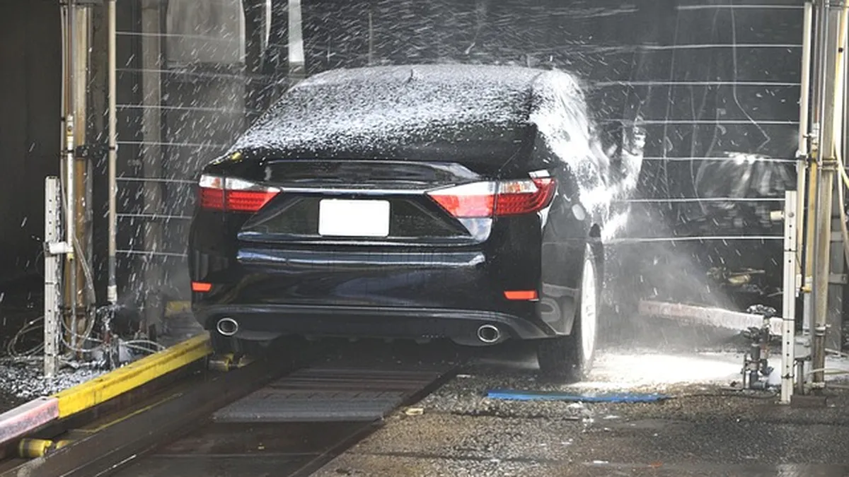 Foamy soap covering a car during a wash, illustrating soft-contact and touchless cleaning methods