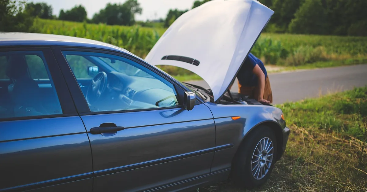 Car parked on a country roadside with the hood raised