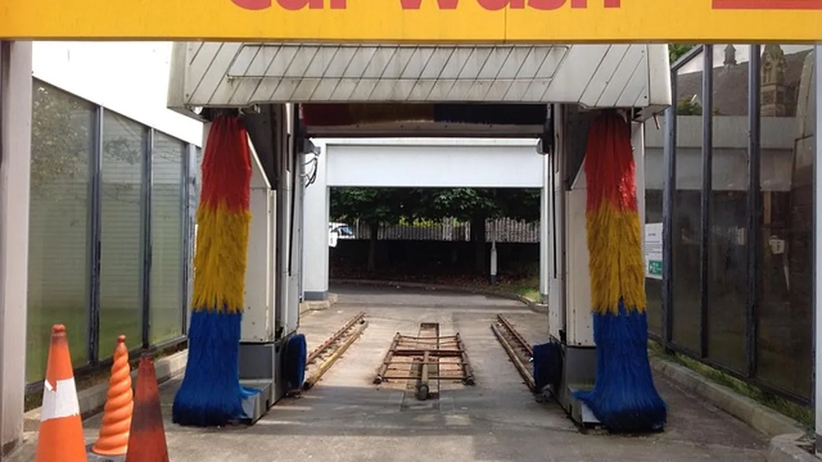 Automatic car wash brushes spinning over a vehicle, the equipment often blamed for paint scratches