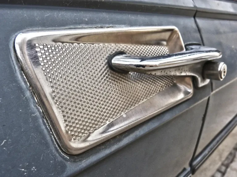 Close-up of a chrome exterior car door handle set in a recessed panel