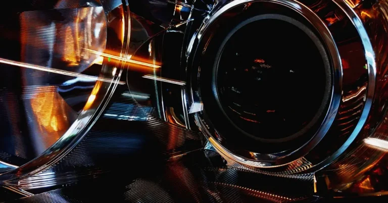 Close-up of a car headlight lens showing the projector and reflector