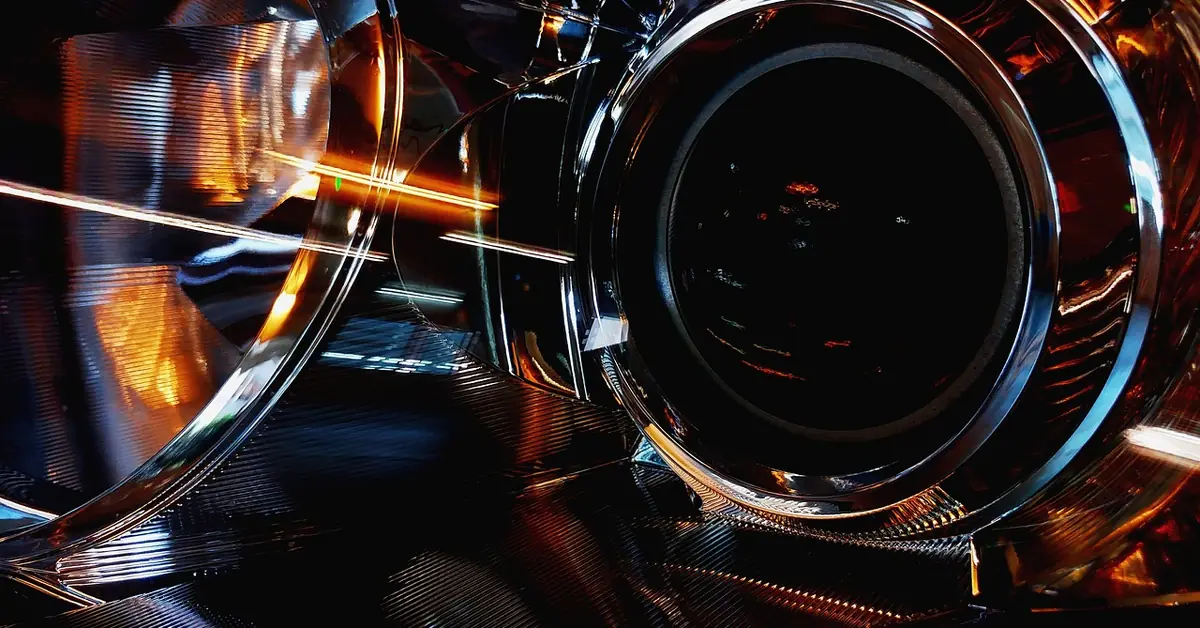 Close-up of a car headlight lens showing the projector and reflector