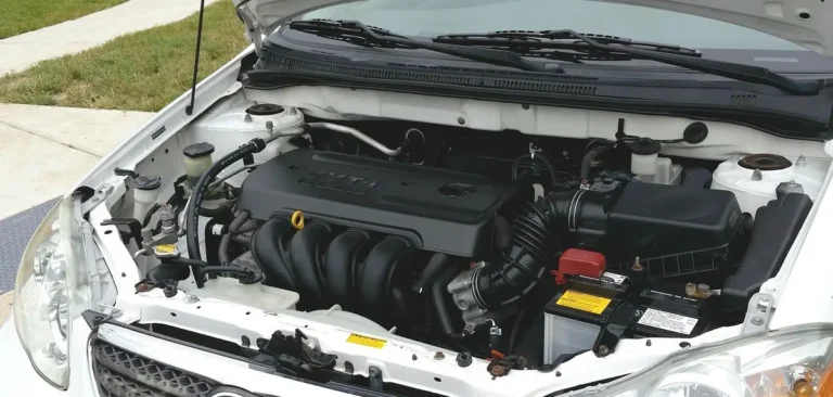 Car engine bay with the 12V starter battery visible near the air intake