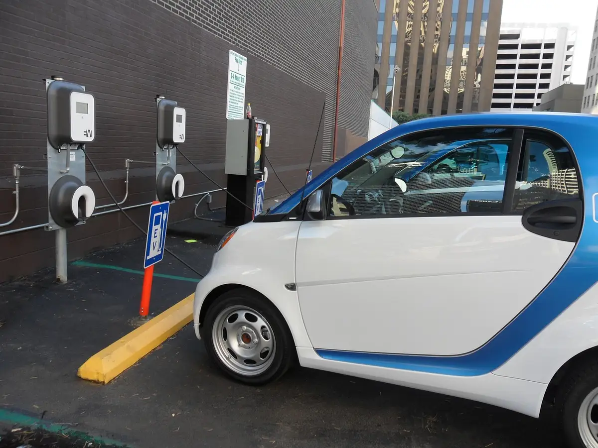 Small electric car parked next to wall-mounted EV charging stations