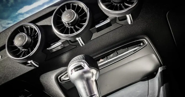 Car dashboard air vents and gear shifter inside a vehicle