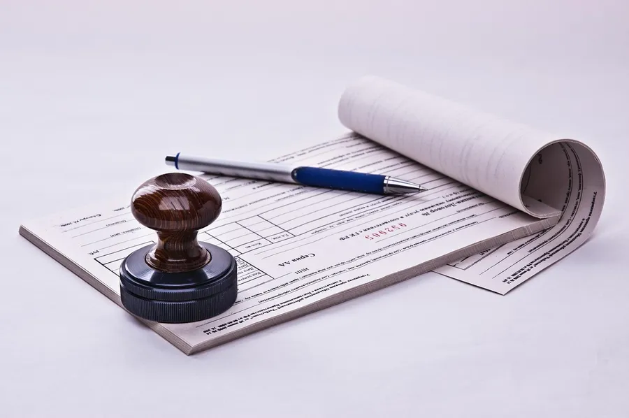 A receipt book with a pen and a round stamp on a desk