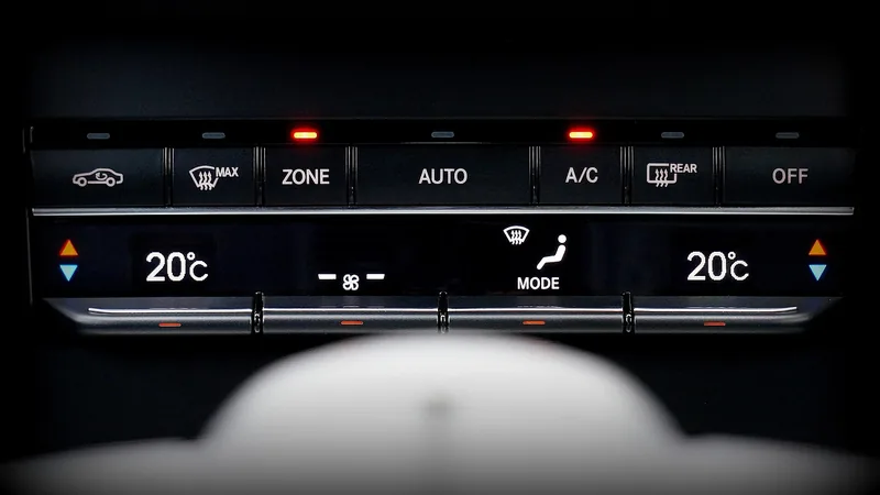 Dual-zone car climate control panel with the A/C button lit and both sides set to 20 C