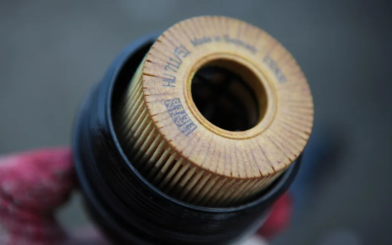 Cylindrical fuel filter mounted along the engine bay fuel line