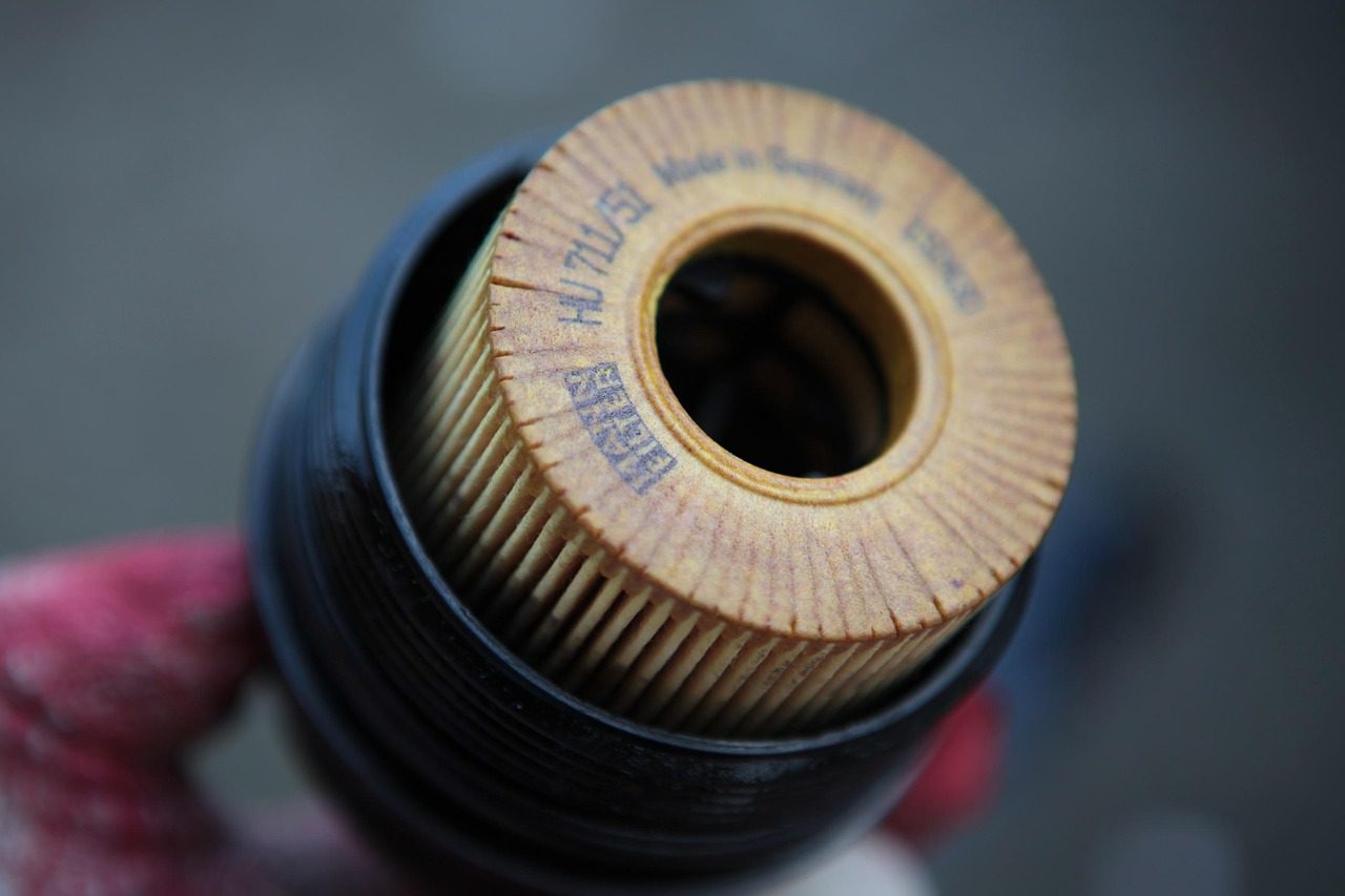 Mechanic checking engine oil level and condition with a dipstick