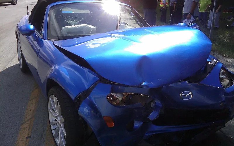 Damaged car front bumper showing dent and scrape needing repair