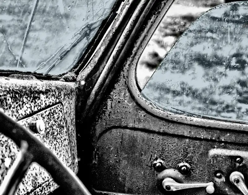 Interior door handles and window cranks on a weathered older car door